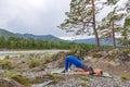 Blond beautiful girl is making a warm-up lying on the stone ground in the pose of the bridge, resting his palms and shoulder Royalty Free Stock Photo