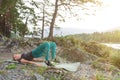 Blond beautiful girl is making a warm-up lying on the stone ground in the pose of the bridge, resting his palms and shoulder Royalty Free Stock Photo