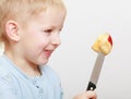 Blond boy child kid preschooler with kitchen knife cutting fruit apple Royalty Free Stock Photo