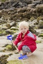 Blond boy digging with spade