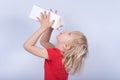 Blond boy drinking milk out of carton resting his head back. Child holds juice pack