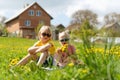 Blond boy and girl in sunglasses sit in grass on meadow. Siblings rest in dandelion field. Happy child summer outdoors Royalty Free Stock Photo