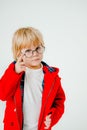 Blond boy with glasses. A beautiful blonde child. Boy in a red coat