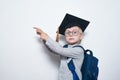 Blond boy in glasses with serious look shows on board. Boy wearing student hat. Kids achievement. Copy space