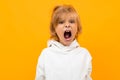 Blond boy grimaces on a yellow studio background close-up Royalty Free Stock Photo