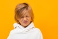 Blond boy grimaces on a yellow studio background close-up Royalty Free Stock Photo