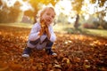 Blond boy hold colorful leaves