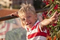 blond boy looks at the camera and throws his hand up with a vict Royalty Free Stock Photo