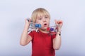 Blond boy playing with two miniature grocery carts. kids store