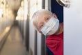 Blond boy in protective mask rides train compartment. Traveling during a quarantine. Empty train Royalty Free Stock Photo