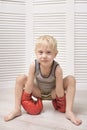 Blond boy in red boxing gloves. Relaxation Royalty Free Stock Photo