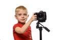 Blond boy shoots video on DSLR camera. Front view. White background, isolate Royalty Free Stock Photo