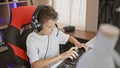 Blond boy streamer playing video game using computer at gaming room Royalty Free Stock Photo