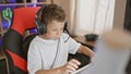 Blond boy streamer playing video game using computer at gaming room Royalty Free Stock Photo