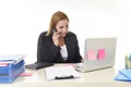 Blond businesswoman working at office laptop computer desk talking on mobile phone smiling Royalty Free Stock Photo