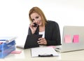 Blond businesswoman working at office laptop computer desk talking on mobile phone smiling Royalty Free Stock Photo