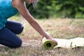 Blond caucasian girl rolling yoga mat. Close-up of attractive young girl folding green yoga mat. Healthy lifestyle. Healthy,