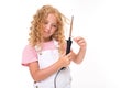 Blond caucasian girl twists her hair with a hair curler on a white background