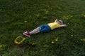 Blond child boy on green grass . Kid lying in dandelions flower filed. Happy childhood, summer day Royalty Free Stock Photo