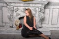 Blond child girl in a black dress by the fireplace Royalty Free Stock Photo