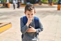 Blond child student coughing at park