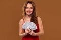 Blond curly woman weared in a red sexy dress is holding some blue gambling chips in her hands. Casino. Royalty Free Stock Photo