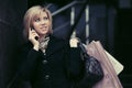 Blond fashion woman with shopping bags calling on cell phone Royalty Free Stock Photo