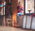 Blond female drinks hot coffee near the window. Royalty Free Stock Photo