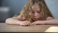 Blond female orphan girl sitting at social worker office, meeting new family