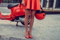 Woman`s legs near red scooter. Royalty Free Stock Photo