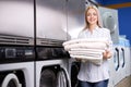 Young european caucasian woman with blond hair smiling happy doing chores at the laundry Royalty Free Stock Photo