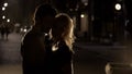 Blond female teasing and cuddling boyfriend in the night street, silhouettes Royalty Free Stock Photo