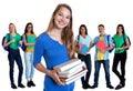 Blond german female student with books and group of students Royalty Free Stock Photo