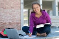 Blond german female student learning with book and computer in front of school building Royalty Free Stock Photo