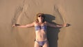 Blond girl in a bathing suit and black sunglasses on a white sand beach by the ocean on vacation. Beautiful model with Royalty Free Stock Photo