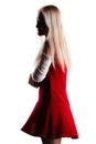 Blond girl with a broken arm in plaster, wearing red dress, isolated on white background Royalty Free Stock Photo