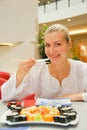 Blond girl eats sushi Royalty Free Stock Photo