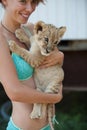 Blond girl holding cute little lion cub Royalty Free Stock Photo