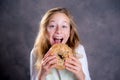 Blond girl looking through a big bagel Royalty Free Stock Photo
