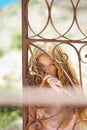 Blond girl in Mediterranean rusted gate at sea Royalty Free Stock Photo