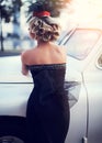 Blond girl model with bright makeup and curly hairstyle in retro style posing near old white car Royalty Free Stock Photo