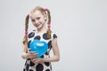 Blond Girl With Pigtails Posing in Polka Dot Dress Against White. Holding Blue Air Balloon