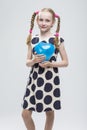Blond Girl With Pigtails Posing in Polka Dot Dress Against White.