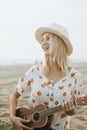 Blond girl playing ukulele for her friends at the beach Royalty Free Stock Photo