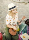 Blond girl playing ukulele for her friends at the beach Royalty Free Stock Photo