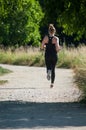 Blond girl running in park on back view