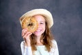 Blond girl with straw hat looking through a big bagel Royalty Free Stock Photo