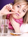 Blond girl is taking a pil Royalty Free Stock Photo
