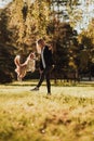 Blond girl train her dog border collie in green park in sunshine Royalty Free Stock Photo