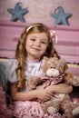 Blond girl with tresses and a teddy bear Royalty Free Stock Photo